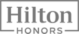 The image shows the logo for "Hilton Honors," a loyalty program by Hilton Hotels, featuring bold text within a rectangular frame.