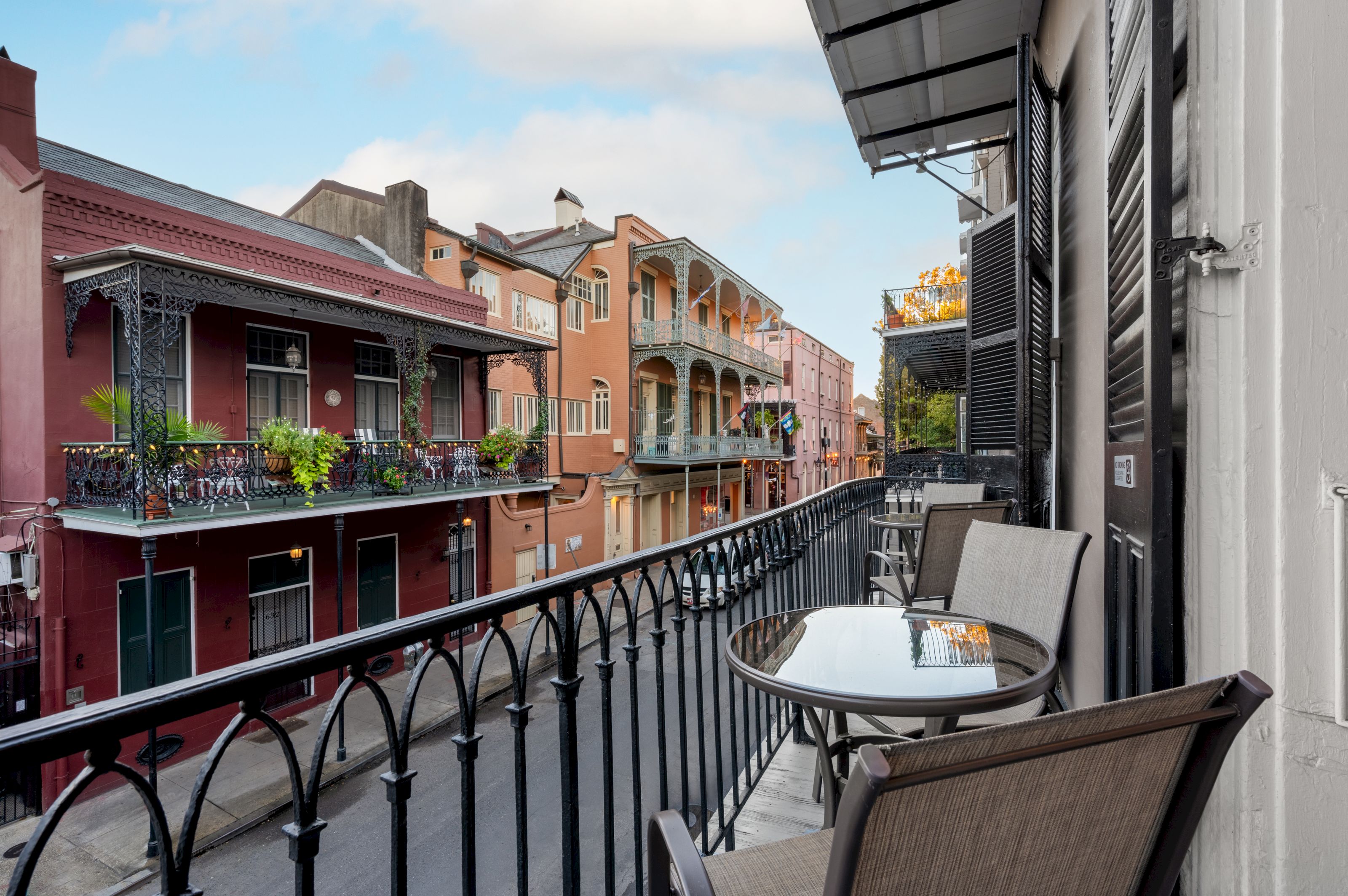 A balcony with a table and chairs overlooking a street with historic buildings
